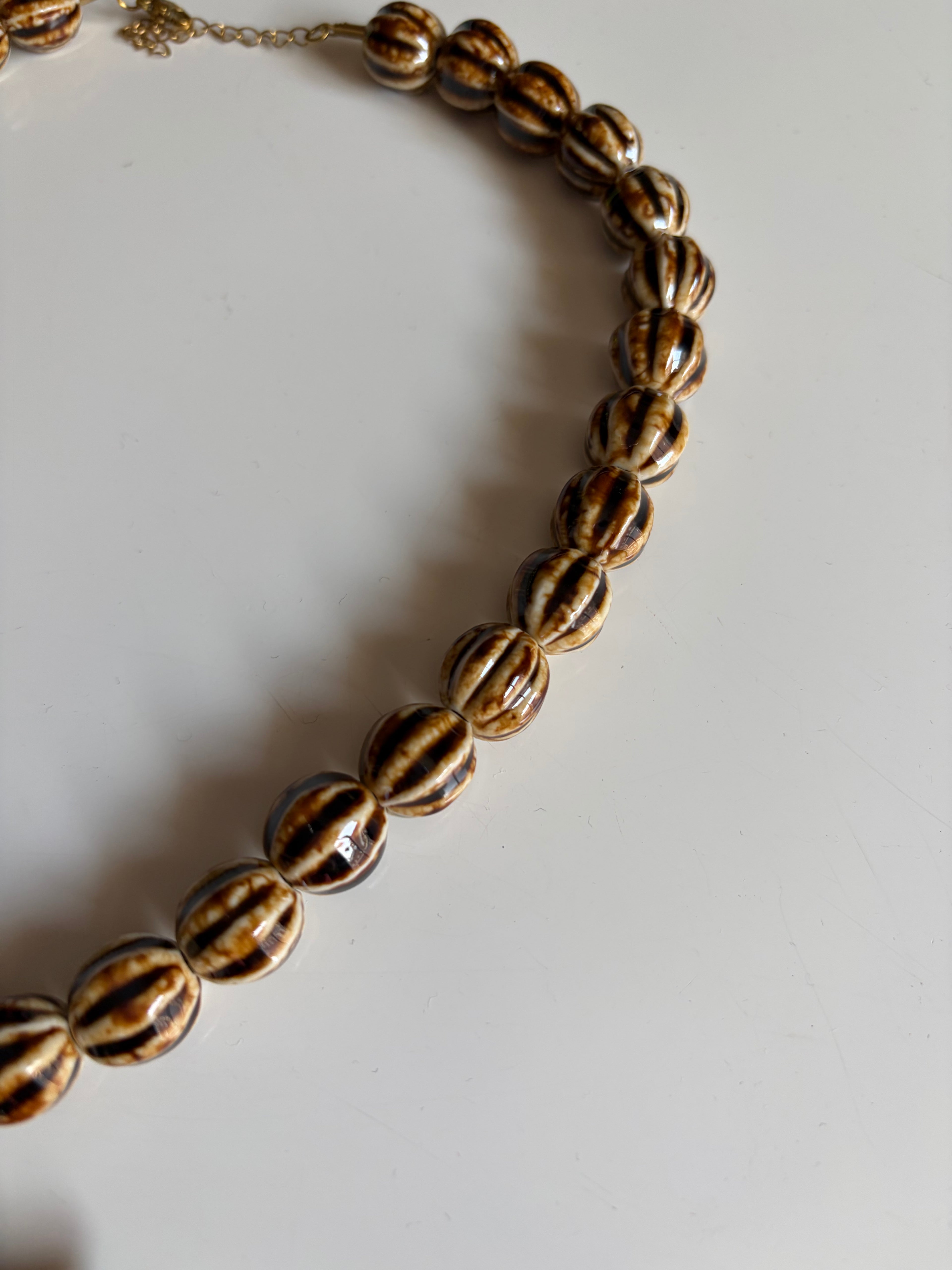 Detalle de las cuentas de cerámica rayadas en tonos beige y marrón del Collar Estrella de Mar | Zeyala